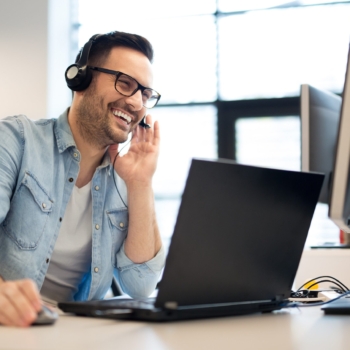 Young smiling male call center operator doing his job with a hea