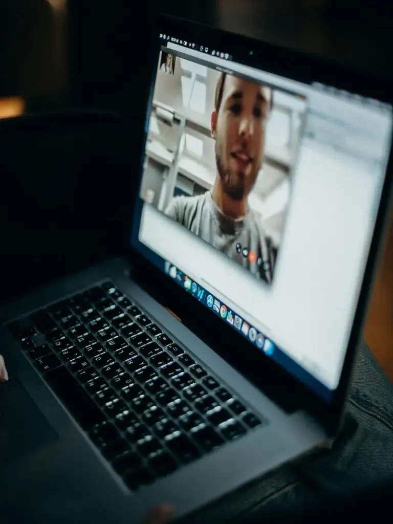 Persönliche Beratung: Mann im Videoanruf auf Laptop. Experten-Tipps für Ferienhausverwaltung.