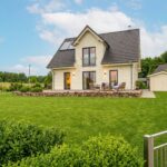 Gepflegtes Ferienhaus mit Rasenfläche und Gartenmöbeln für das Favorent Ferienhausmanagement.