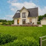 Gepflegtes Ferienhaus mit Rasenfläche und Gartenmöbeln für das Favorent Ferienhausmanagement.