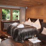 Schlafzimmer mit Holzwänden und Aussicht, ideal für die Vermietung Ihrer Ferienimmobilie mit Favorent.