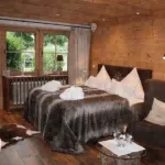 Schlafzimmer mit Holzwänden und Aussicht, ideal für die Vermietung Ihrer Ferienimmobilie mit Favorent.