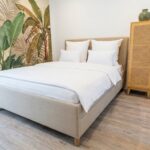 Schlafzimmer mit Doppelbett, Schrank und Dschungeltapete, ideal für die Ferienhausverwaltung durch Favorent.
