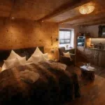 Holzvertäfelter Wohnbereich mit Bett und Küchenzeile, geeignet für die Vermietung als Ferienimmobilie.