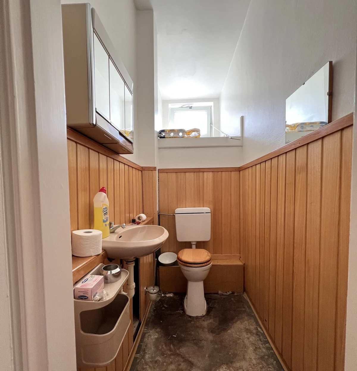 Altes WC mit Holzverkleidung vor dem Umbau