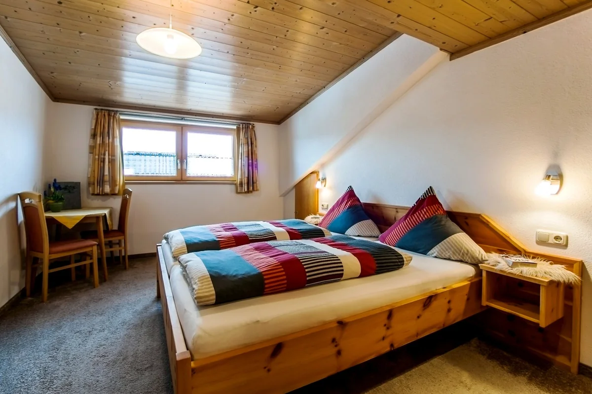 Schlafzimmer einer Ferienwohnung mit Holzbett, Arbeitsprobe von Fotofavorit