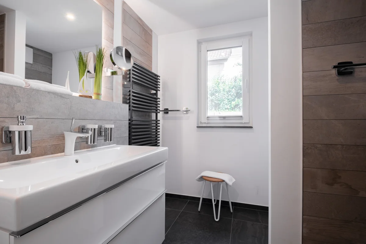 Helles Badezimmer mit Waschtisch, Spiegel und Fenster