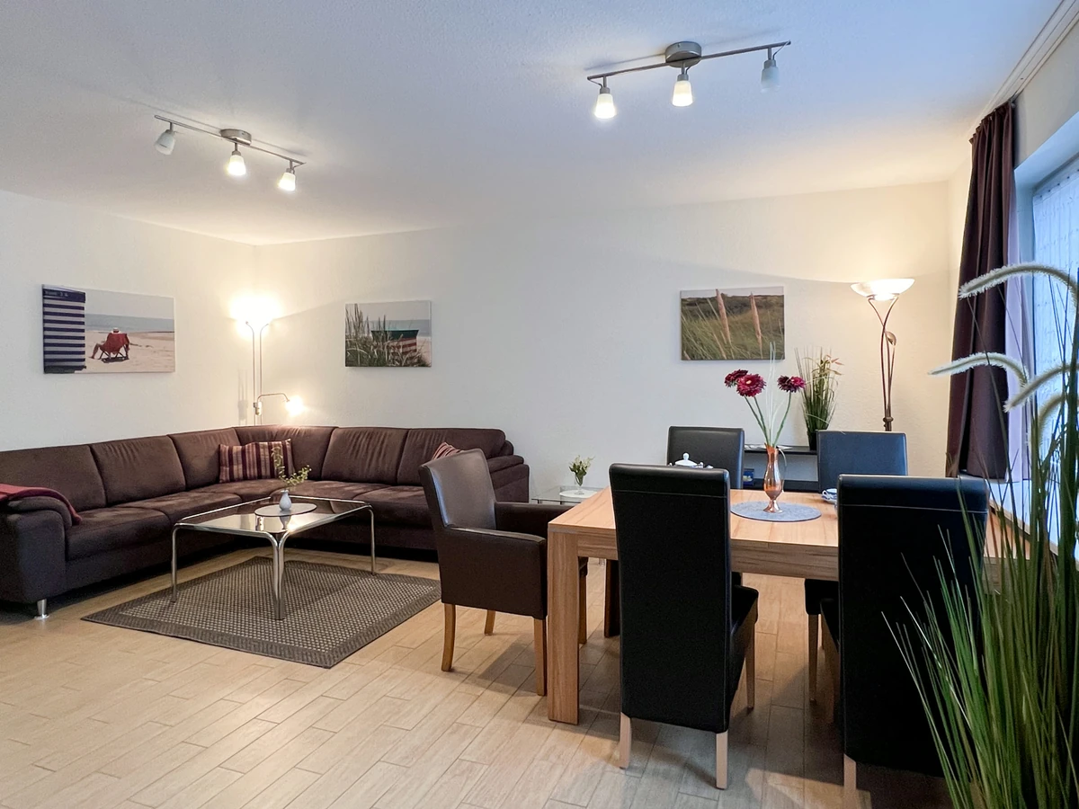 Wohnzimmer im Haus Juist vorher, mit dunklem Ecksofa, Esstisch und schwarzen Stühlen