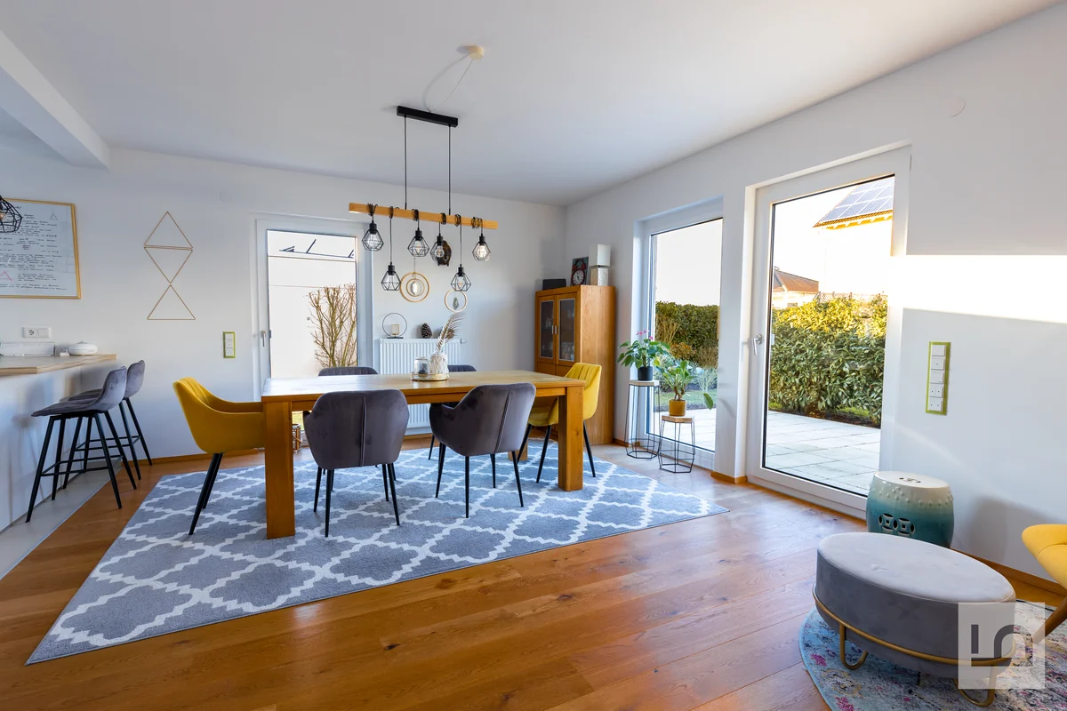 Heller Essbereich mit Holztisch, Pendelleuchte und Terrassentür zum Garten