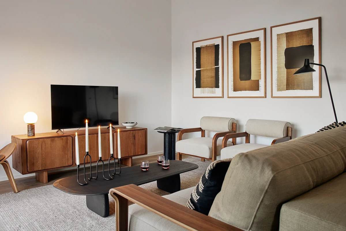 Wohnzimmer im Penthouse der Matt Apartments in Offenburg mit Sideboard, Kerzen und drei Bildern in Erdtönen