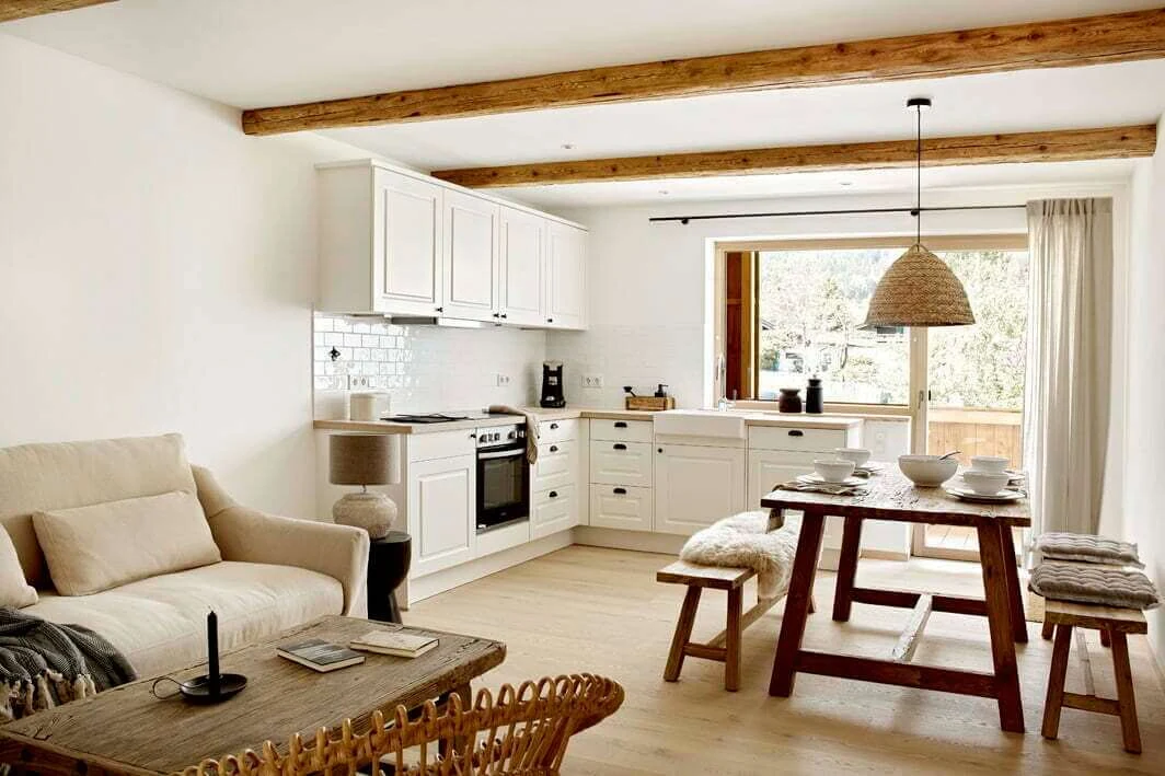 Wohnküche einer Ferienwohnung im Schmiedhof in Geitau mit Holztisch, Bänken und hellem Sofa