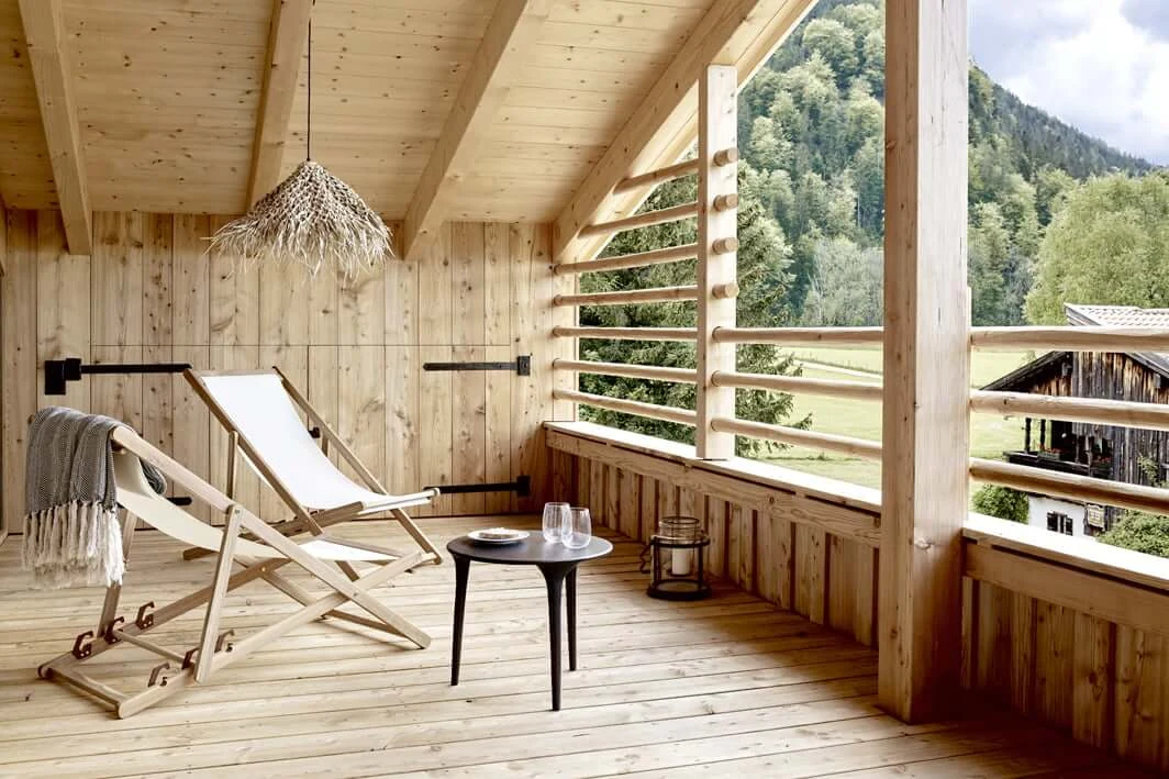 Holzbalkon im Schmiedhof in Geitau mit Liegestühlen und Blick auf die Berge