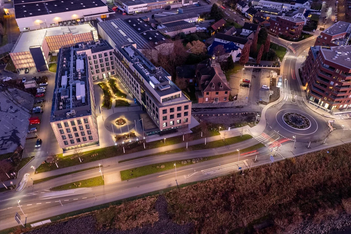 Luftaufnahme eines Stadtviertels mit Kreisverkehr in der Abenddämmerung