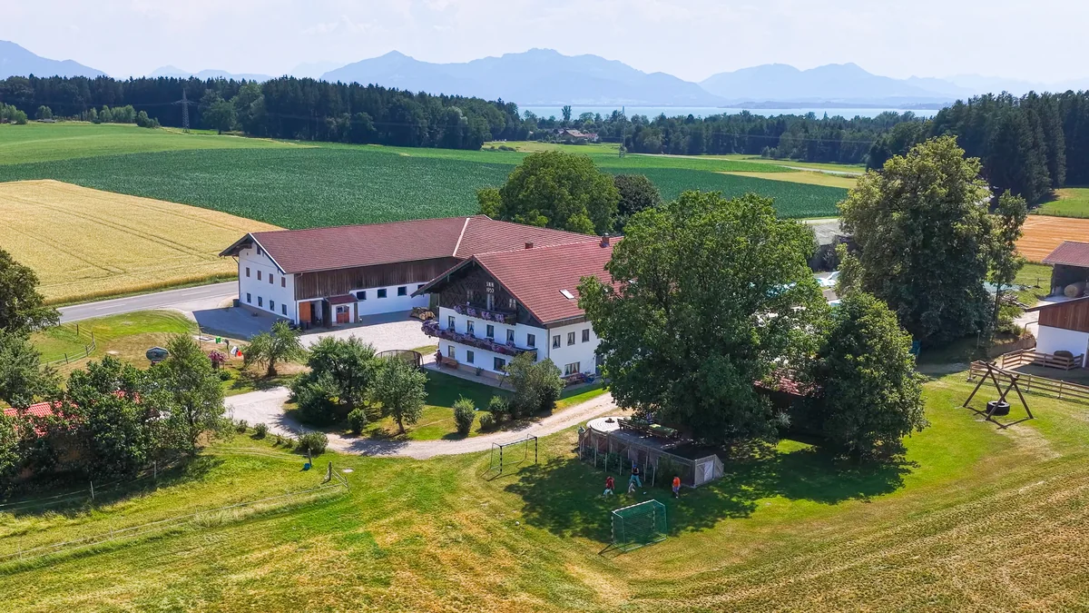 Ferienhof aus der Luft mit Bergen im Hintergrund, Arbeitsprobe von The Landscapers