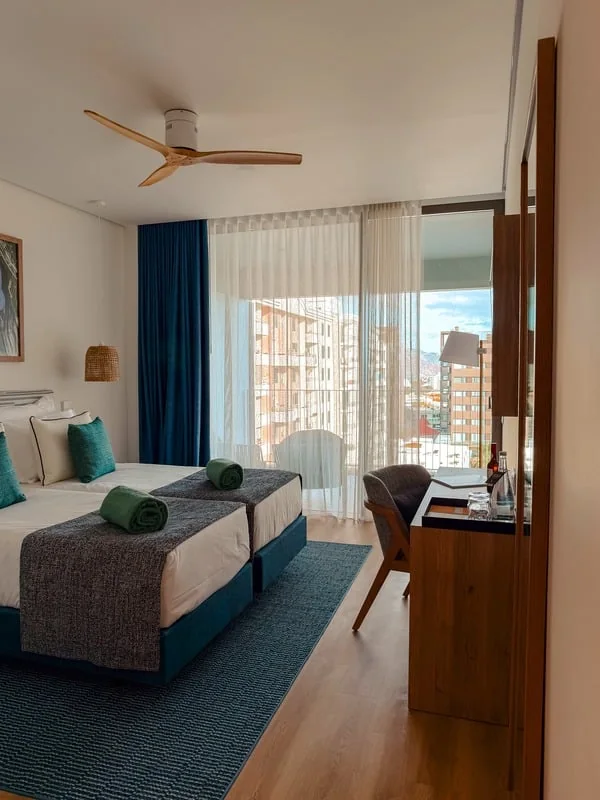 Hotelzimmer mit Deckenventilator und Blick auf die Stadt, Arbeitsprobe von Sandra Loche